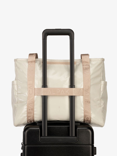 Luggage trolley sleeve of CALPAK Terra 35L Water Resistant Zippered Tote Bag in white sands