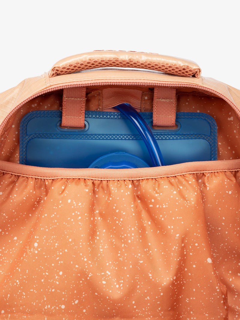 Close up of CALPAK 2L removable hydration reservoir back-slip pocket in orange