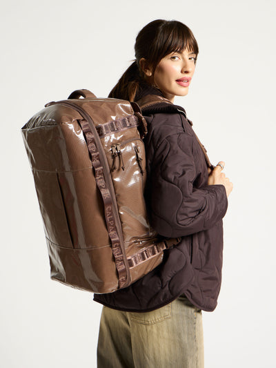 Model wearing CALPAK Terra Large 50L Duffel Backpack as backpack in cacao brown