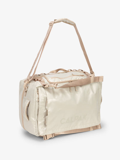 Beige white sands CALPAK  terra large 50L duffel backpack with removable and adjustable body shoulder strap