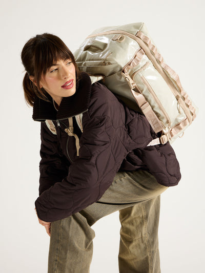 Model wearing CALPAK terra large 50L duffel backpack on back with sternum strap across chest in beige