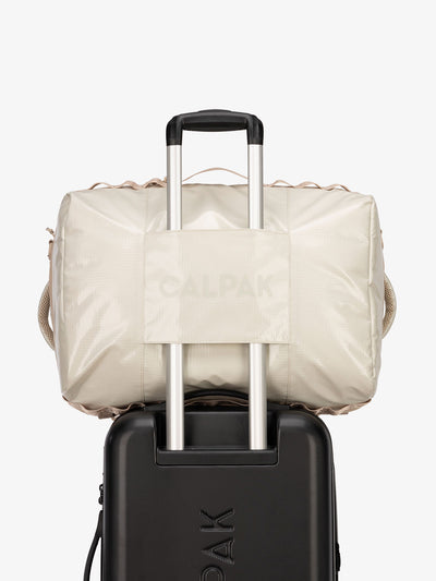 CALPAK Terra Large 50L Duffel Backpack with trolley passthrough in white sands beige