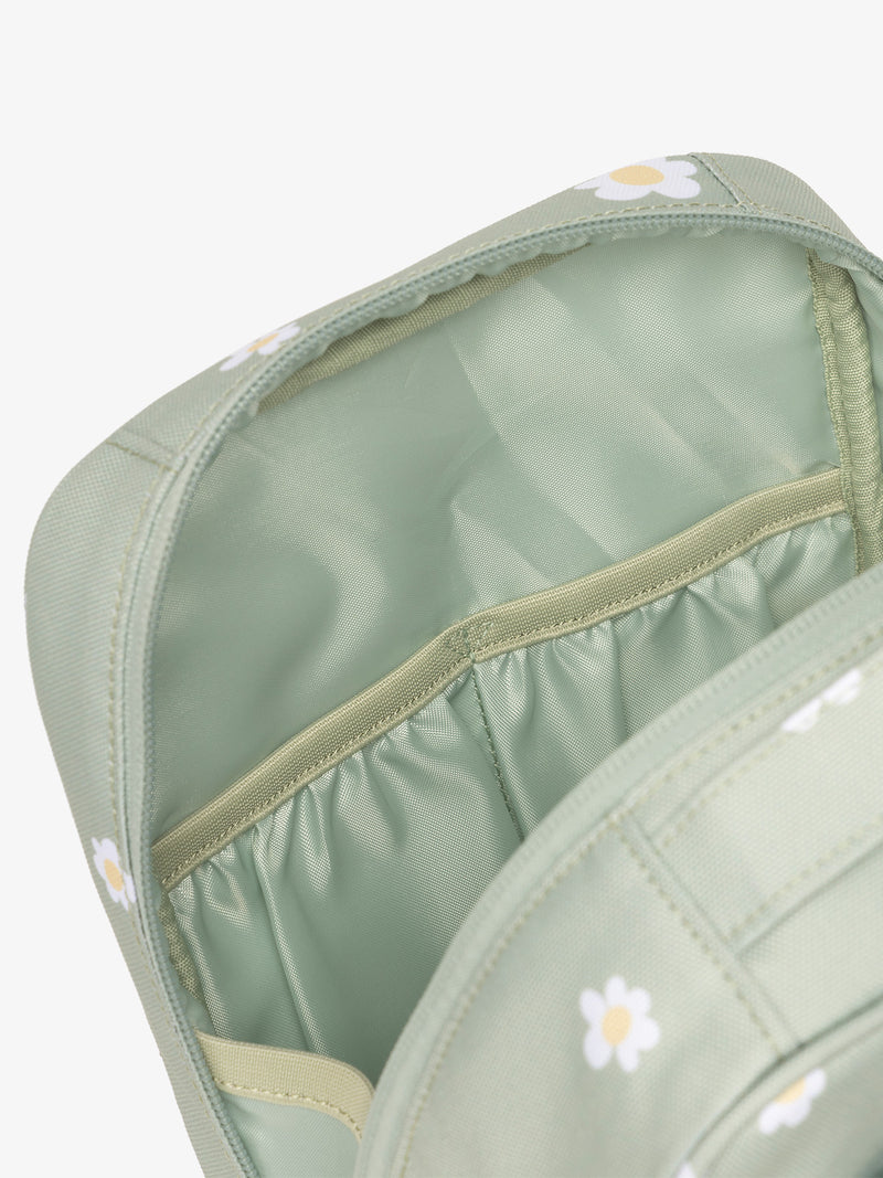 Interior view of CALPAK The Everything Cube featuring water resistant lining and interior pockets in green daisy print