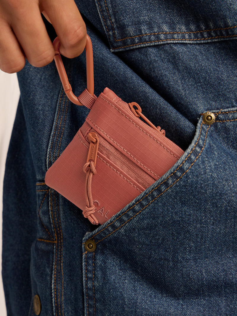 Model clipping in the CALPAK Terra Clippable Card Pouch in red and orange Matte Clay