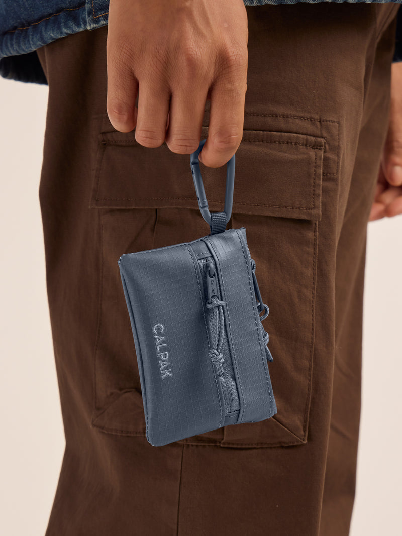 Model clipping in the CALPAK Terra Clippable Card Pouch in blue Matte Indigo