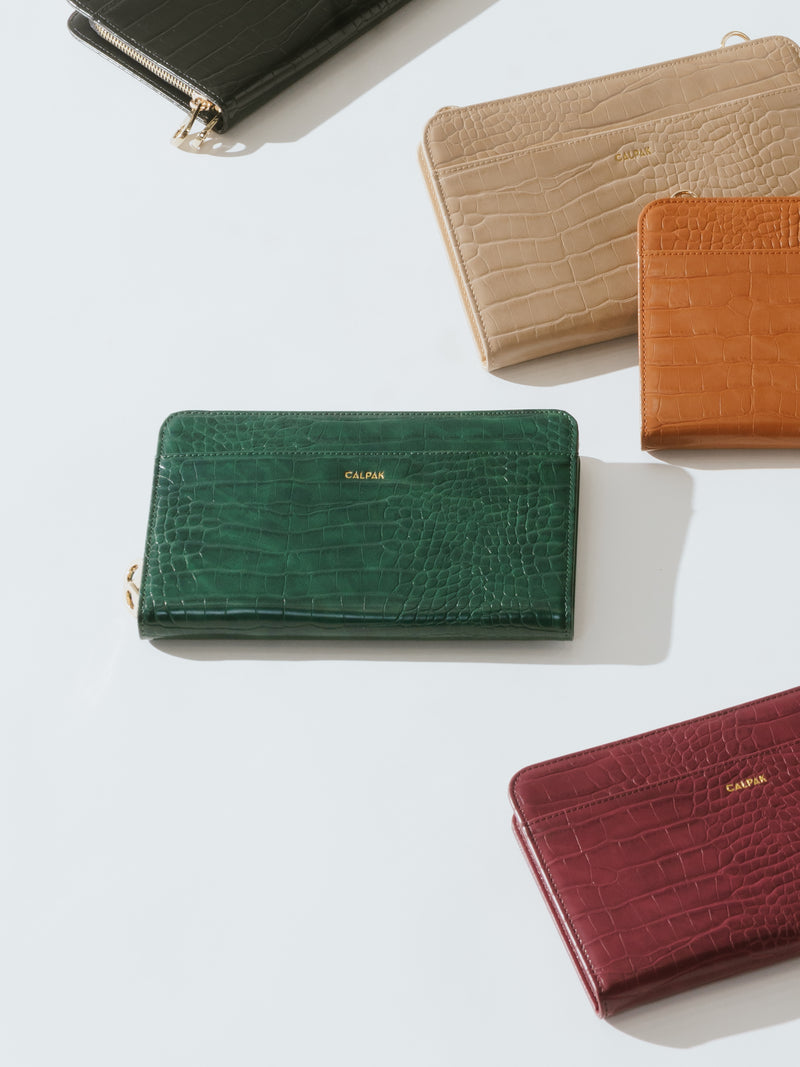 CALPAK passport wallets in emerald, cognac, burgundy, sand, and black