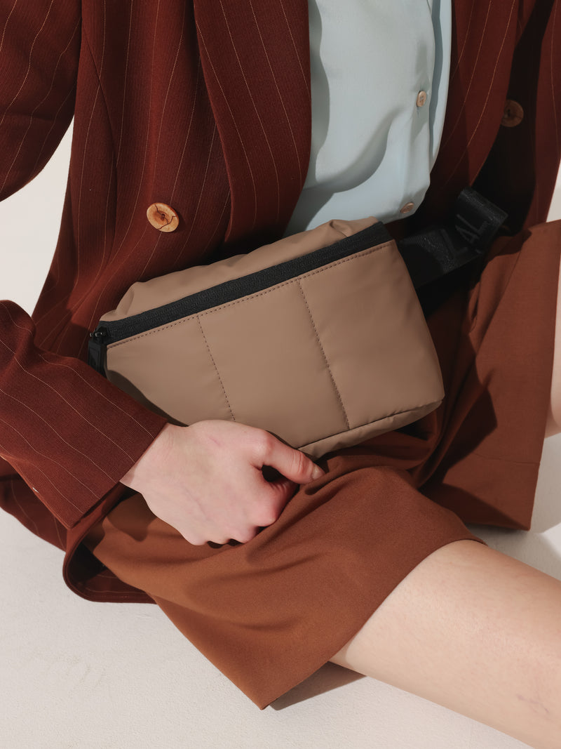 Model wearing CALPAK Luka mini crossbody fanny pack in brown