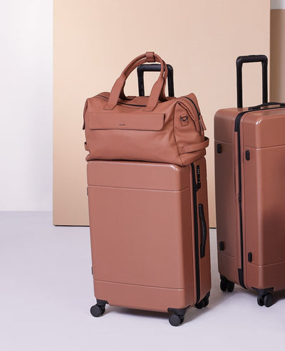 medium 26 inch CALPAK Hue hard shell luggage in brown hazel color